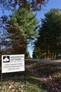 A tree lined street and sign at the home of Chesapeake Cottages
