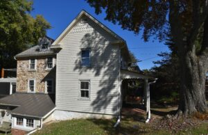 The gable end view of the original Chesapeake Cottage with porches and trees